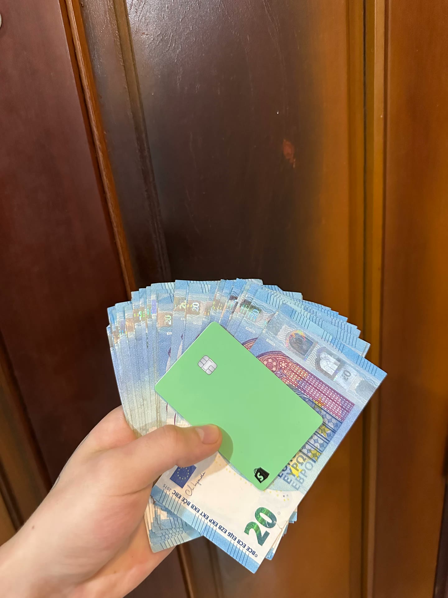 Grüne Karte zusammen mit Euro-Banknoten als Kundenfoto